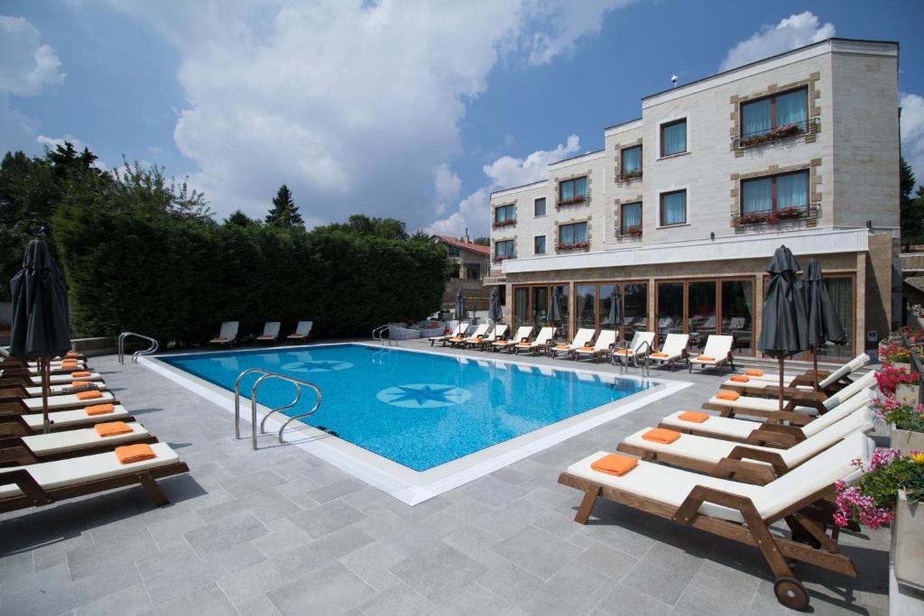 a swimming pool with lounge chairs and a hotel at Marina Residence Boutique Hotel in Varna City