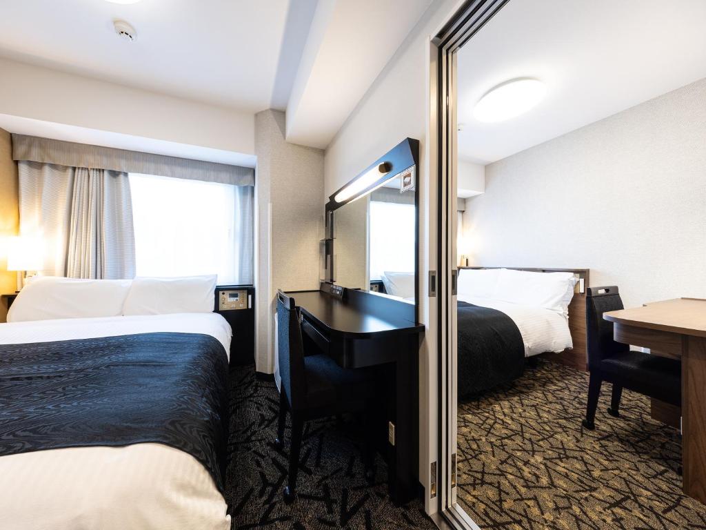Postel nebo postele na pokoji v ubytování APA Hotel Hiroshima Ekimae Shinkansenguchi