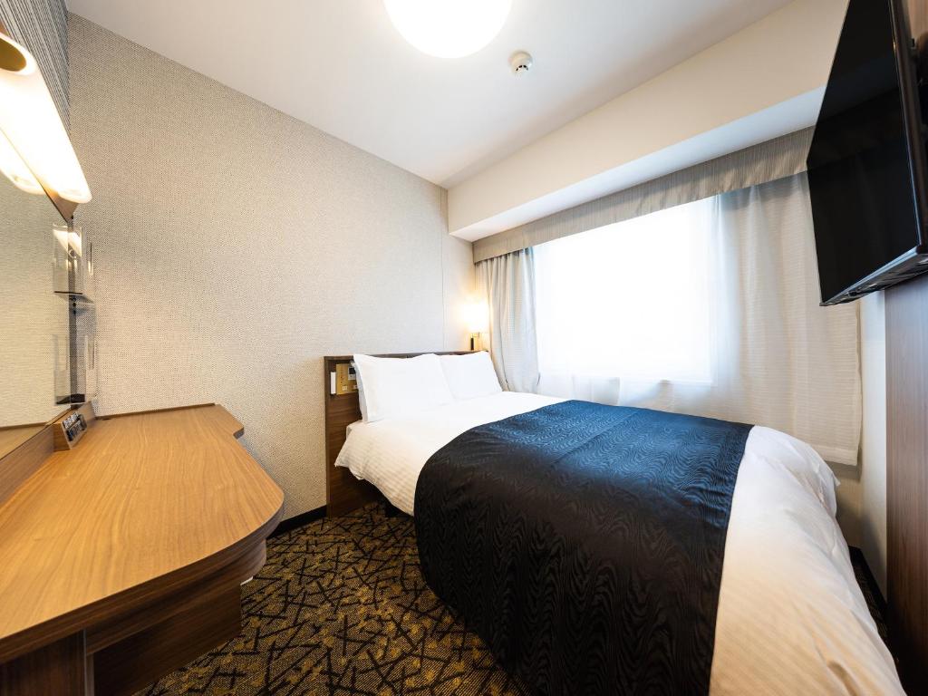 Postel nebo postele na pokoji v ubytování APA Hotel Hiroshima Ekimae Shinkansenguchi