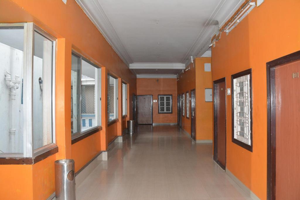 an empty hallway with orange walls and a hallwayngth at Hotel Naveen Residency in Darbhanga