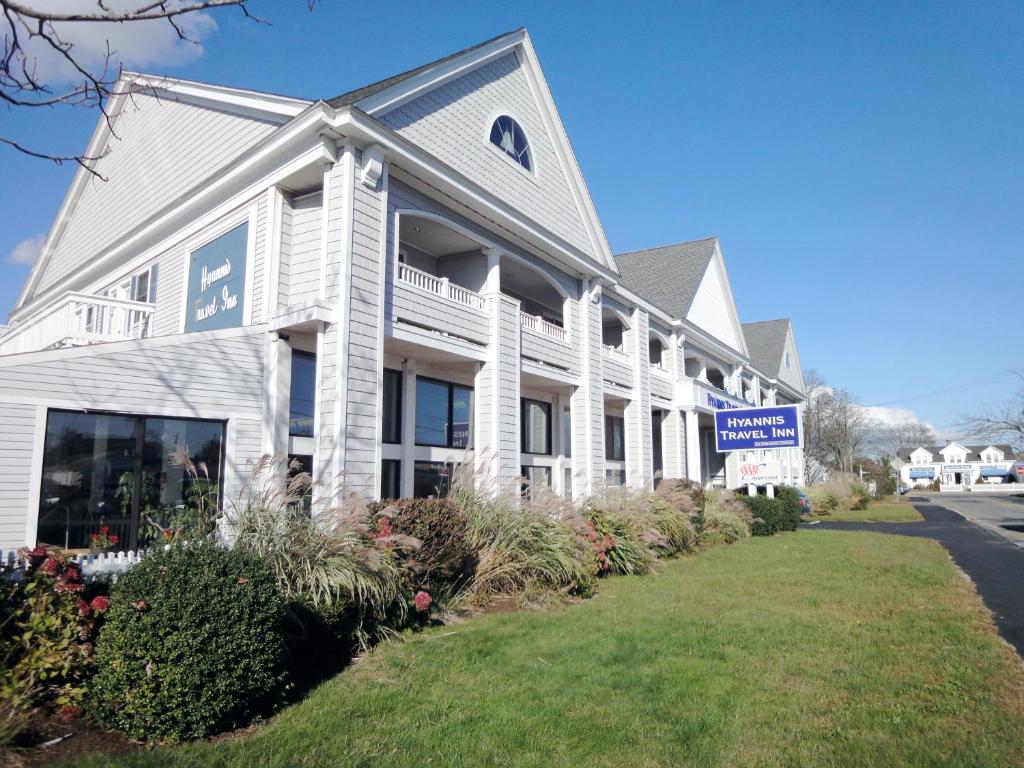 a white building with a sign in front of it at Hyannis Travel Inn in Hyannis