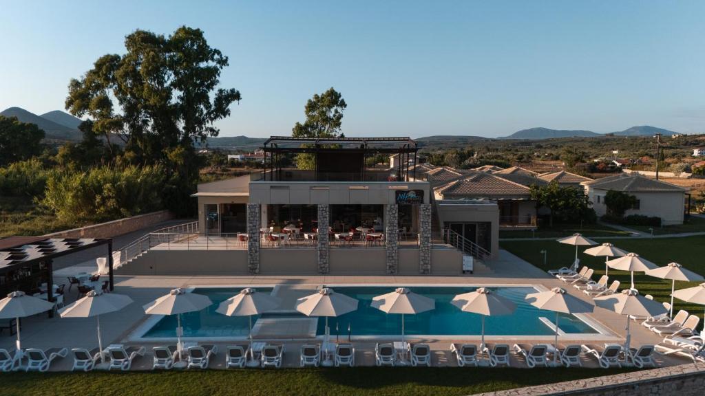 an aerial view of a resort with a pool and umbrellas at Niriides Luxury Villas in Methoni