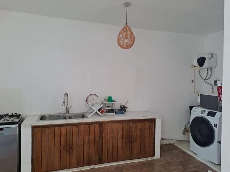 a kitchen with a sink and a dishwasher at Casa con alberca frente del mar de Santa clara Yucatan in Santa Clara