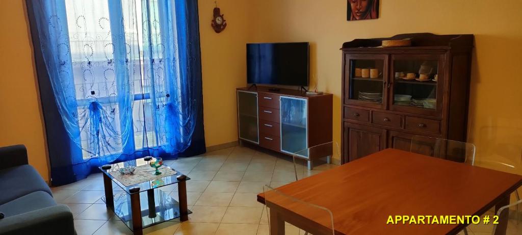salon z kanapą i telewizorem w obiekcie La Casa di Lisa 2 w mieście Valledoria