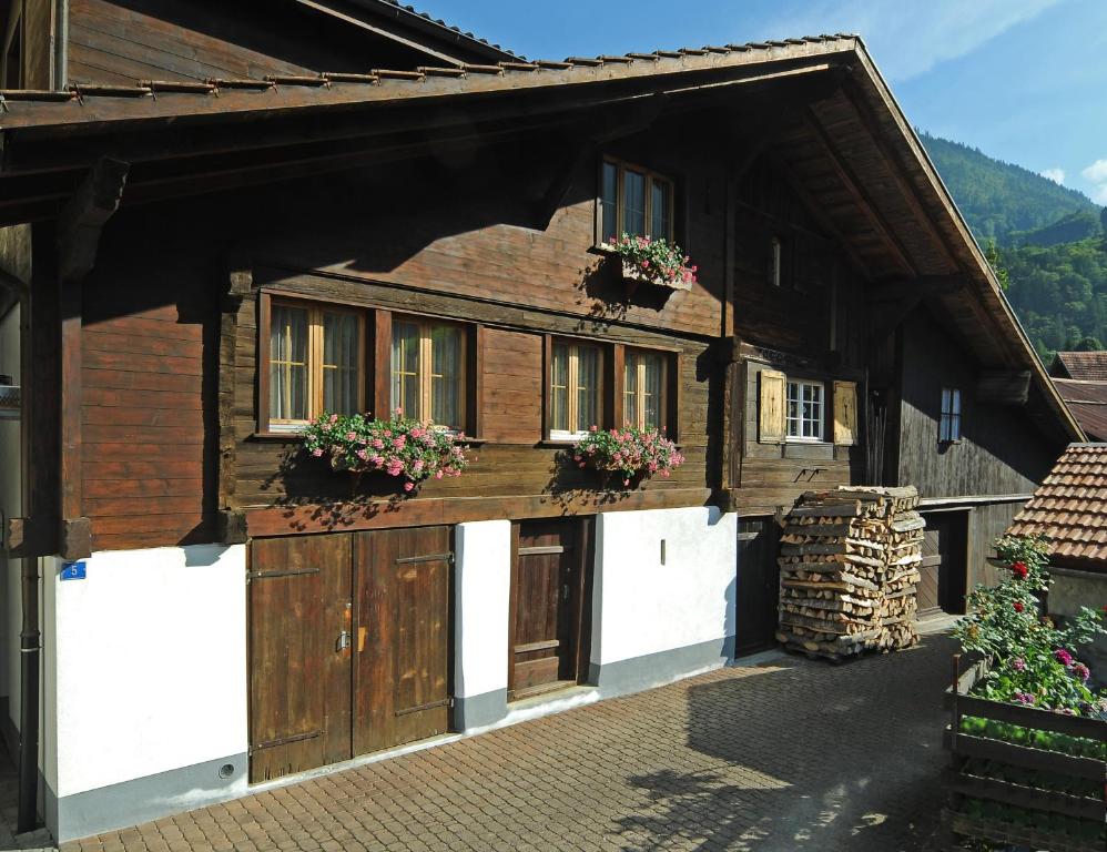 a house with flower boxes on the front of it at Hostel Chalet Stöckli mit Etagendusche in Wilderswil