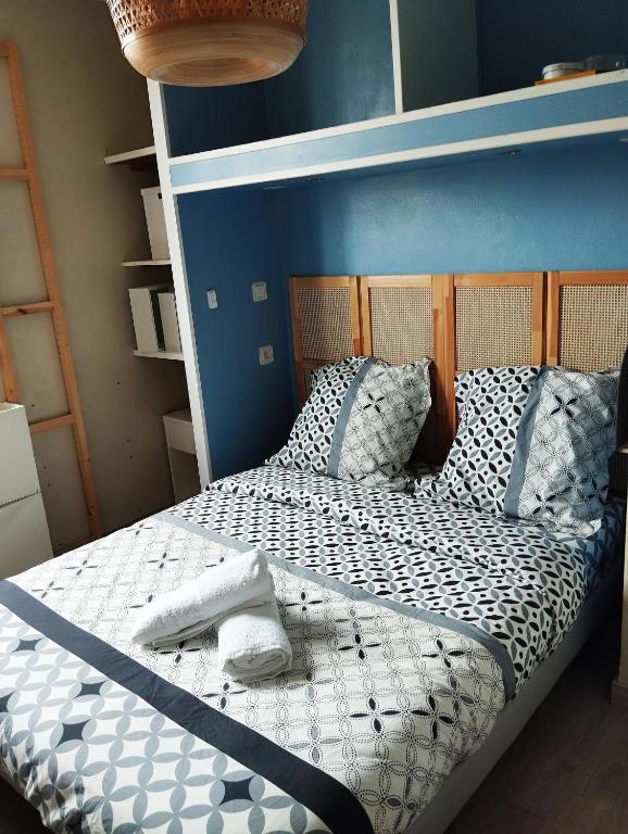 une chambre avec un lit avec un mur bleu dans l'établissement Appartement 5 chambres proche de toute commodité, à Noisy-le-Grand