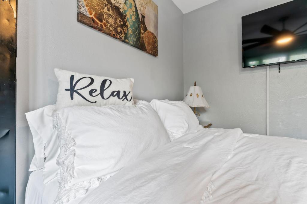 a white bed with white sheets and pillows at Stylish Studio Suite Near Downtown in Anchorage