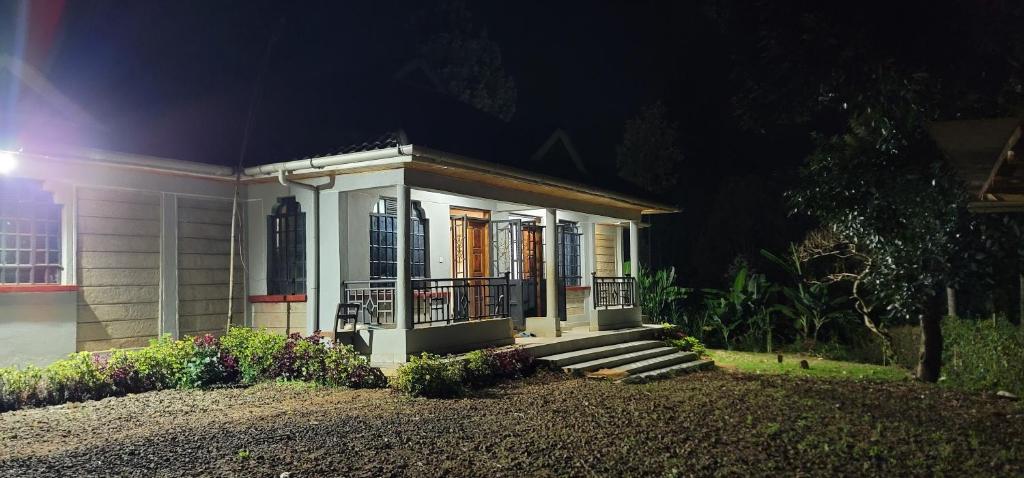 a small house with a porch at night at Aberdare Home in Othaya
