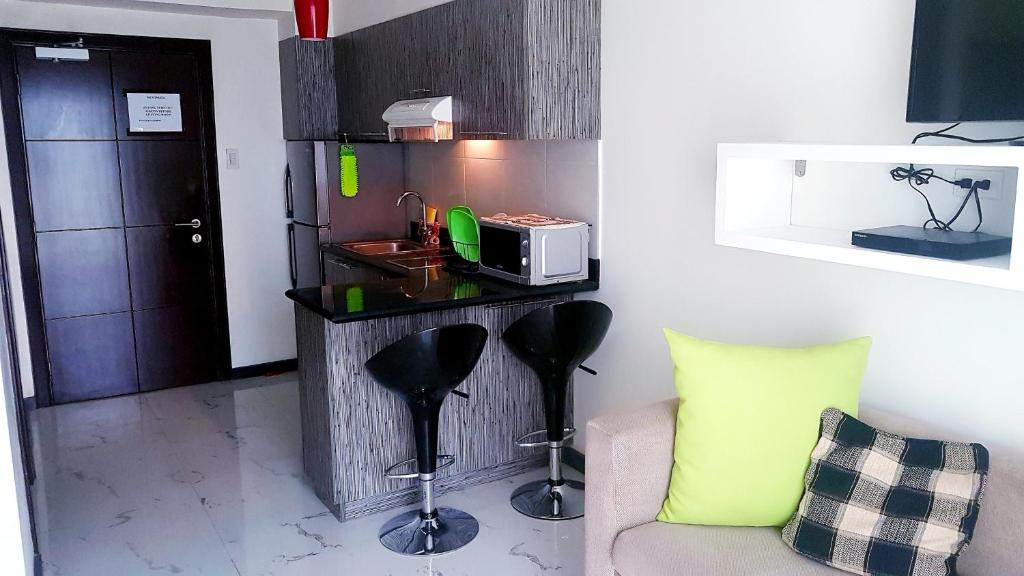 a living room with a couch and a microwave on a counter at Ramos City Suites Central Balcony in Cebu City