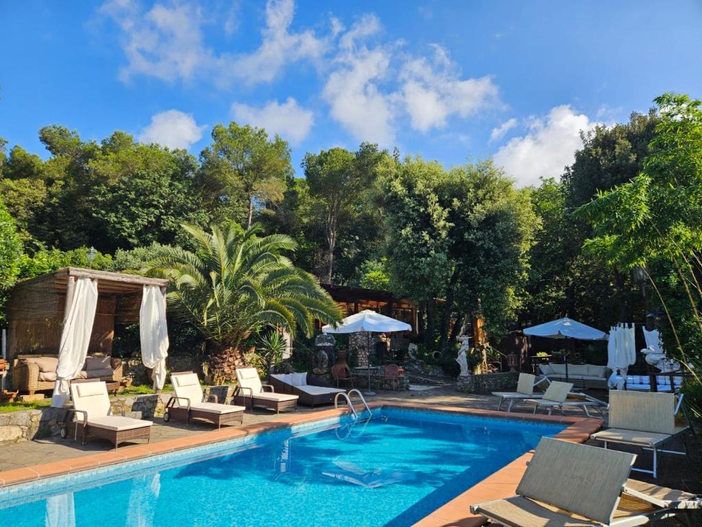 a swimming pool with chairs and umbrellas next to it at Ca' Datu in Finale Ligure