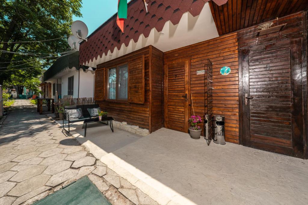 a house with wooden walls and a patio at Бунгало Есмералда in Aheloy