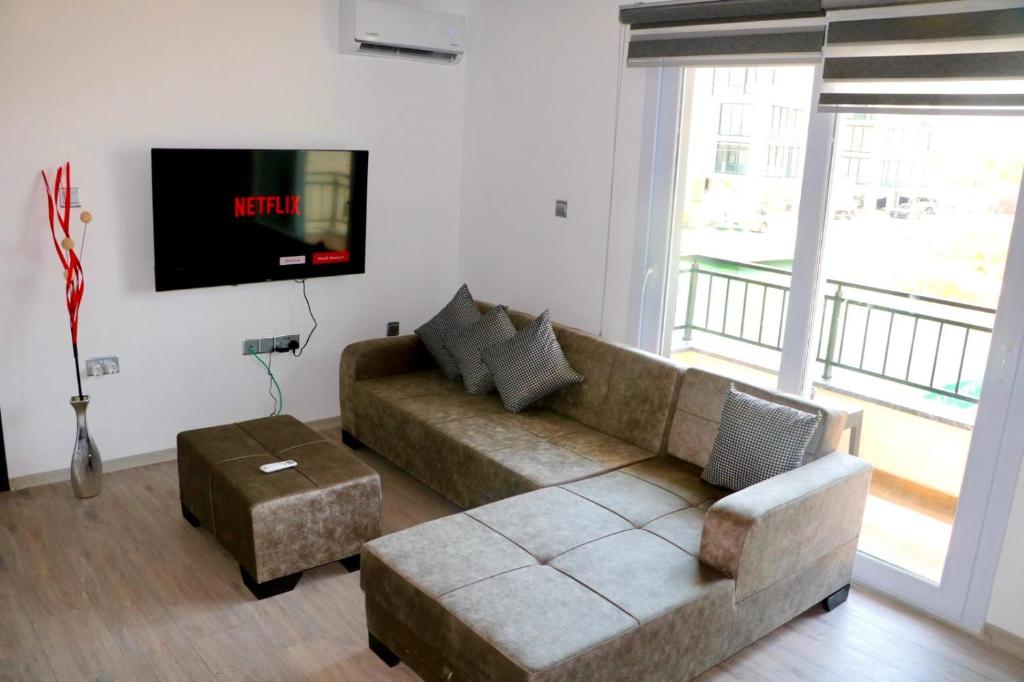 Una sala de estar con un sofá y un televisor de pantalla plana. en Coffee & Sea'troll, en Trikomo