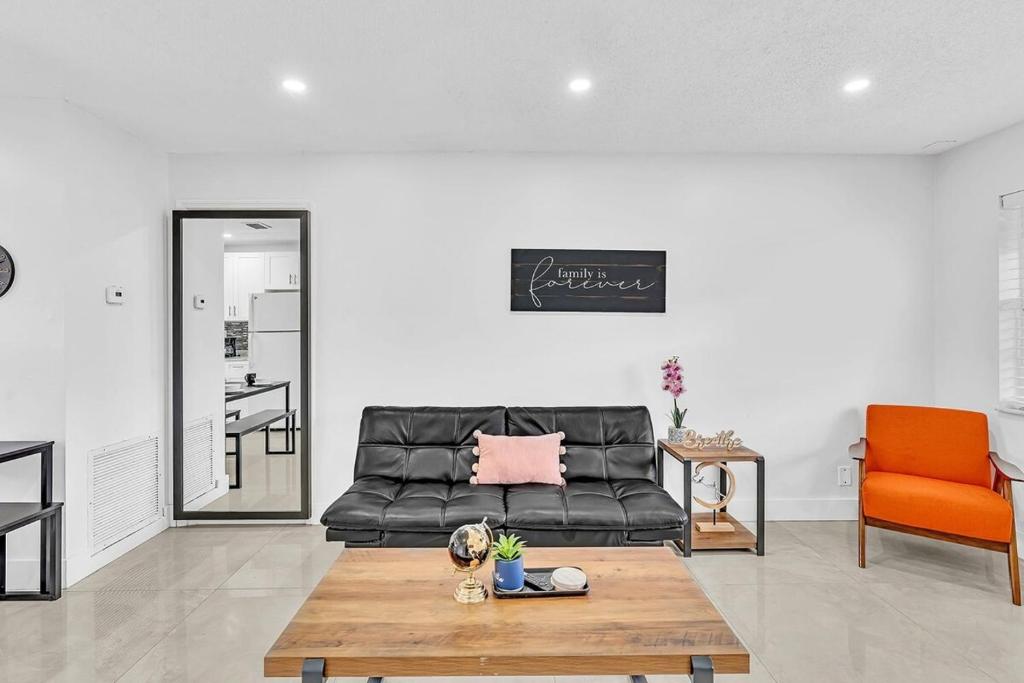 a living room with a black couch and a table at Beach And Hard Rock Hollywood Vacation House Ha02 in Hollywood