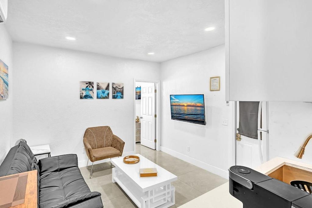 una sala de estar con un sofá y una silla en Boutique One Bdrm Close To Aventura Mall & Beach, en Hallandale Beach