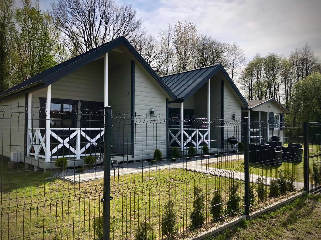 a house with a fence in front of it at Domki SILVER 3 in Jarosławiec