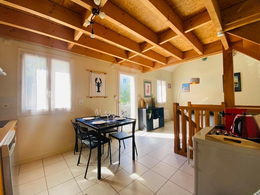 Una cocina y un comedor con mesa y sillas. en Casa Mandarine, en Angers