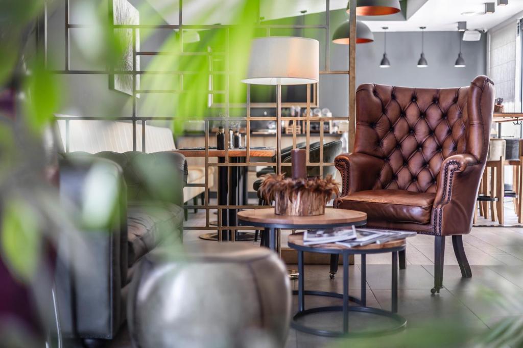 a living room with a chair and a table at Charm Boutique Hotel in Satu Mare