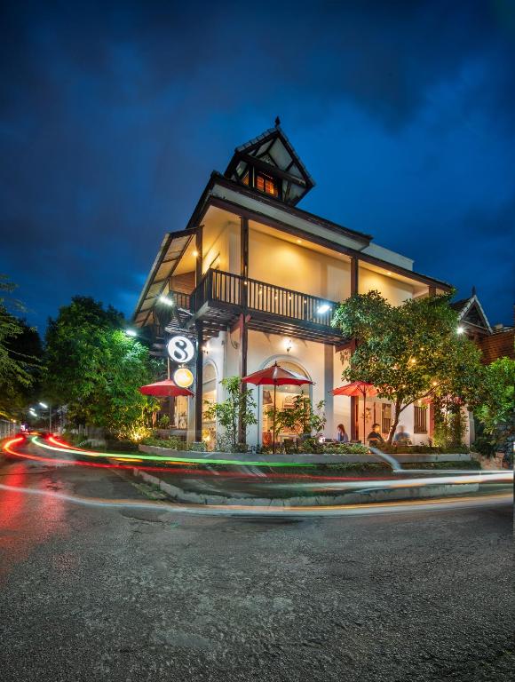 a building with a clock on the side of a street at SHIN Hotel Chiangmai Gate in Chiang Mai