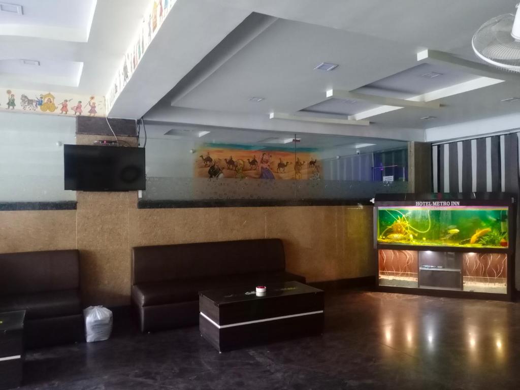 a living room with a couch and a fish tank at Hotel Metro Inn in Ajmer