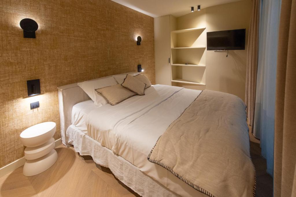 - une chambre avec un grand lit blanc et une télévision dans l'établissement Basfroi Cosy Apartment 1, à Paris
