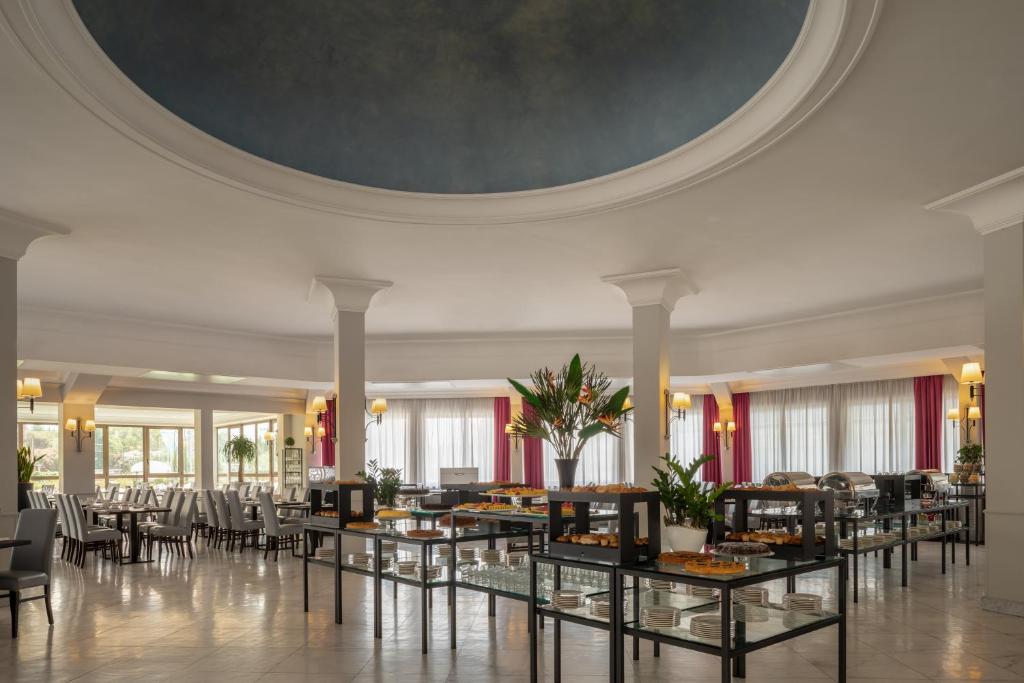 una sala da pranzo con tavoli, sedie e soffitto di Hotel Cristoforo Colombo a Roma