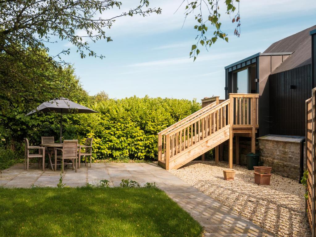 eine Terrasse mit Tisch und Sonnenschirm in der Unterkunft The Old Winery Cottage No2 in Shepton Mallet
