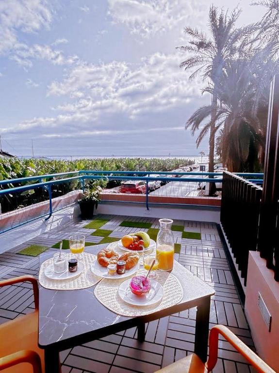 a table with two plates of food and drinks on a balcony at D'Sal y Arena in Breña Baja