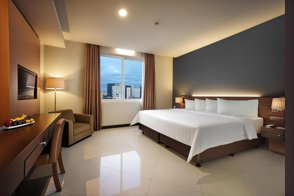 una camera d'albergo con un letto e una finestra di Regantris Malioboro a Yogyakarta