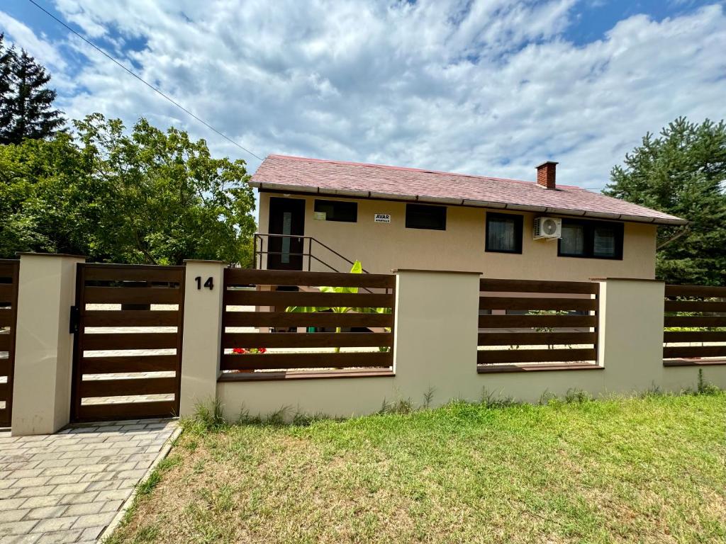 a house with a wooden fence in front of it at Avar Apartman in Nyíregyháza
