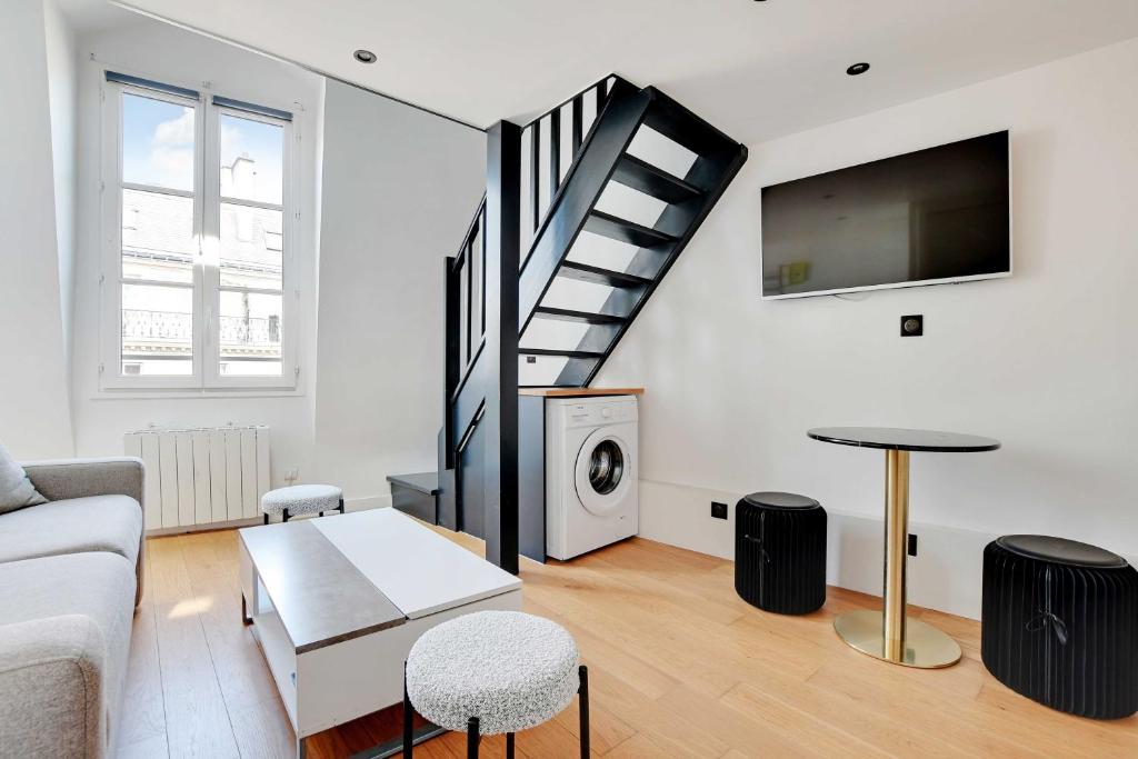 un salon avec un canapé et un escalier dans l'établissement Charming apt with ac -Rue des Archives- le marais, à Paris