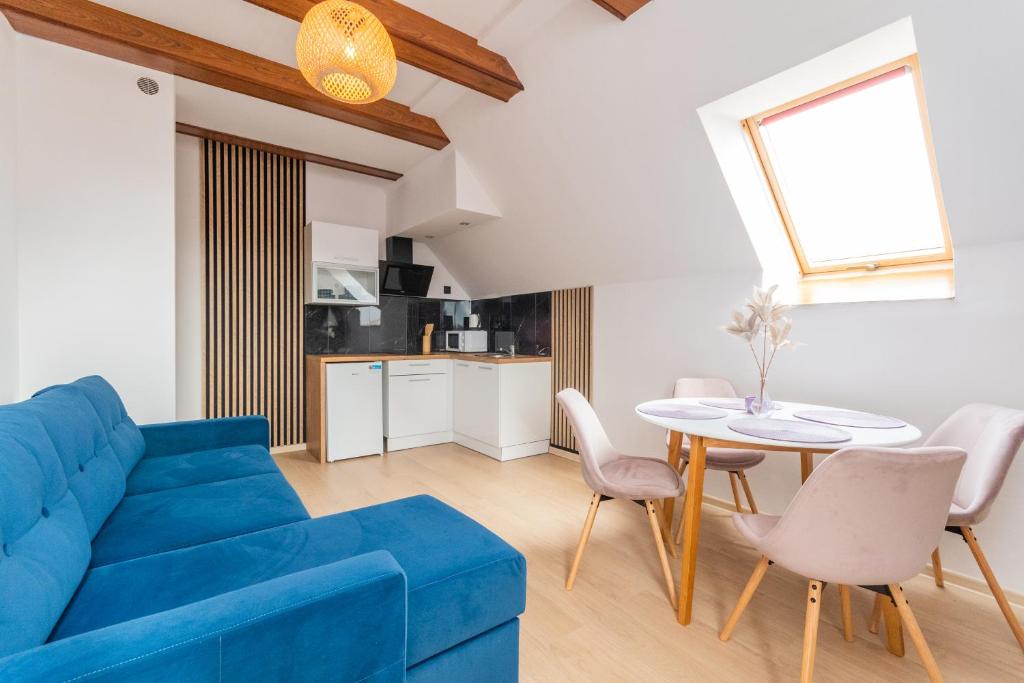 een woonkamer met een blauwe bank en een tafel bij APARTAMENT nr 5 in Kąty Rybackie