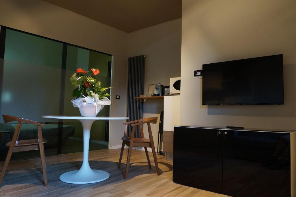 a living room with a table with chairs and a tv at San Donato 40 in Bologna