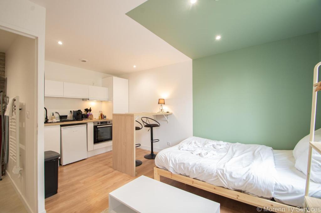 Cette petite chambre comprend un lit et une cuisine. dans l'établissement Studio calme proche Vilaine - Ty ar Sant-Elier, à Rennes