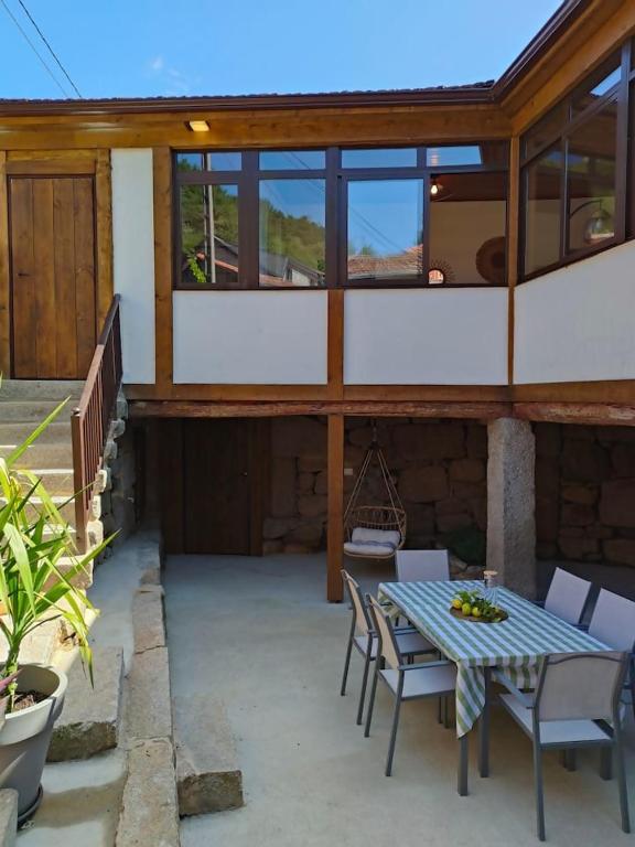 a patio with a table and chairs on a building at Casa Rural Xures Lobios in Pereira