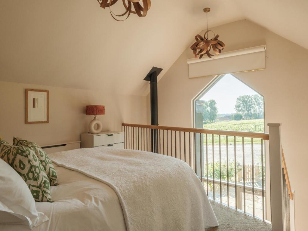 a bedroom with a bed and a large window at The Old Winery Cottage No1 in Shepton Mallet