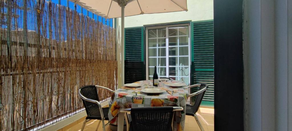 a table and chairs in a room with a fence at Apt 3 Quartos, Terraço, Centro, Prestige For Home in Loulé