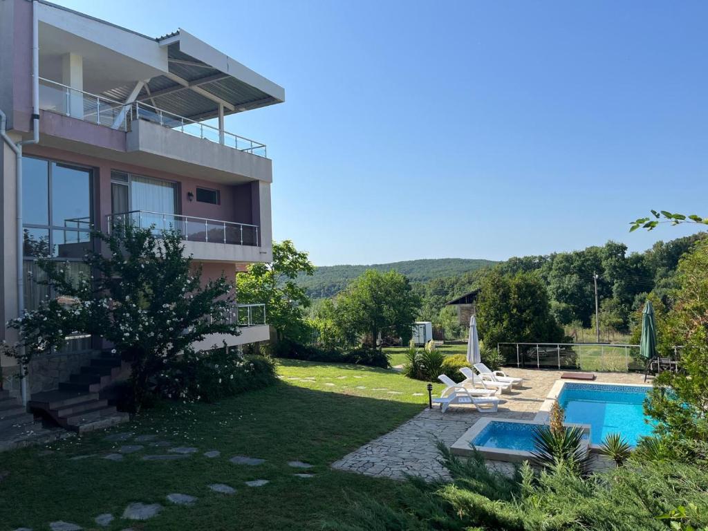una vista de una casa con piscina en Sunny house, en Pismenovo