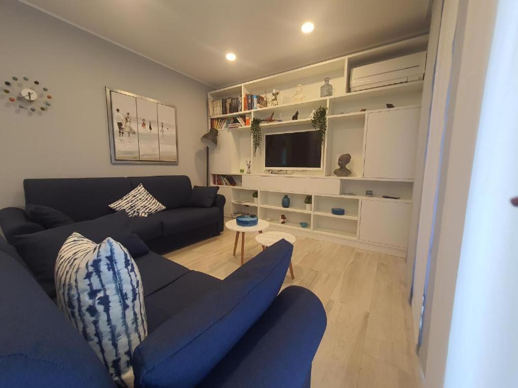 ein Wohnzimmer mit einem blauen Sofa und einem Fernseher in der Unterkunft La Palma in Lerici