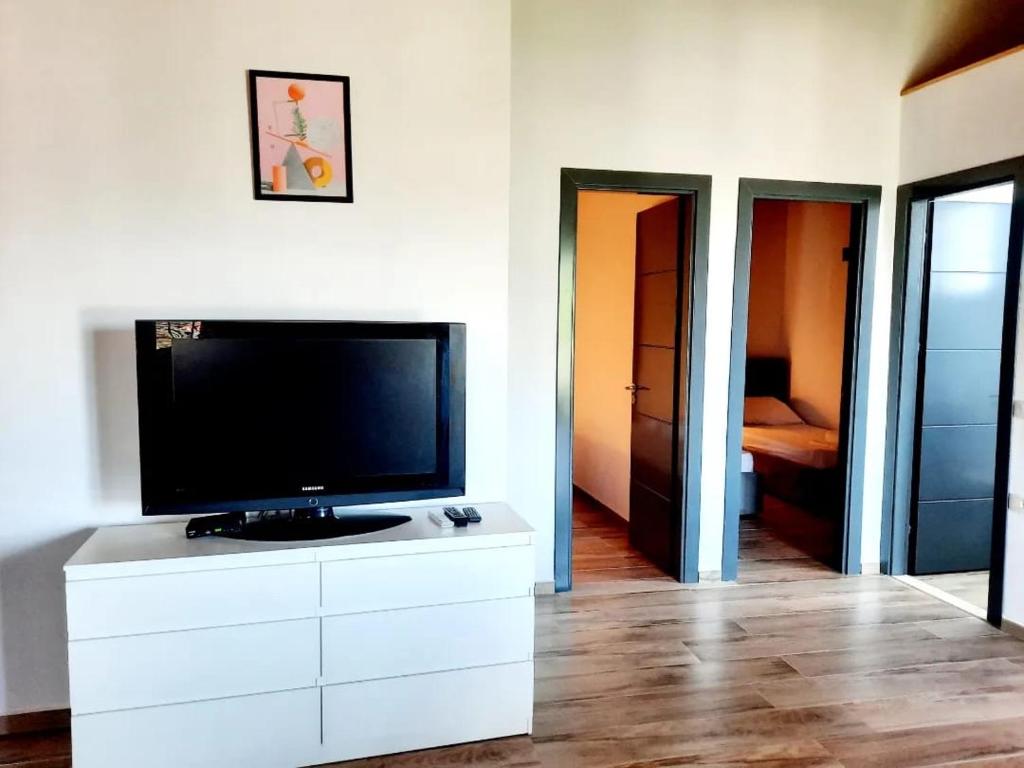 a living room with a flat screen tv on a white dresser at Apartments Alavana in Velipojë