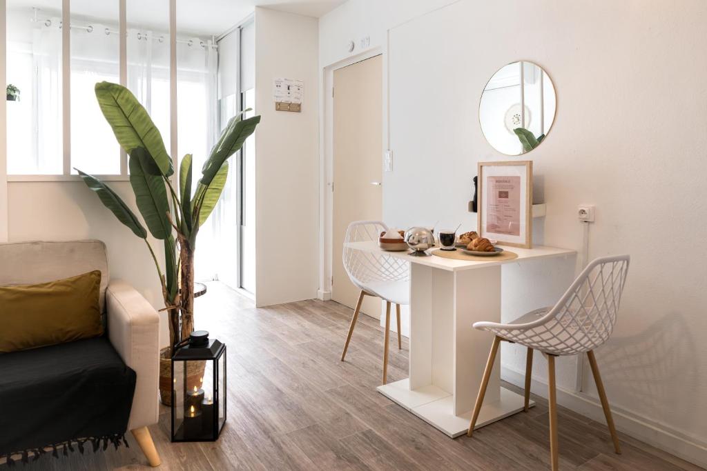 - un salon avec une table, des chaises et un miroir dans l'établissement Le Boho Chic Studio Cosy, à Narbonne