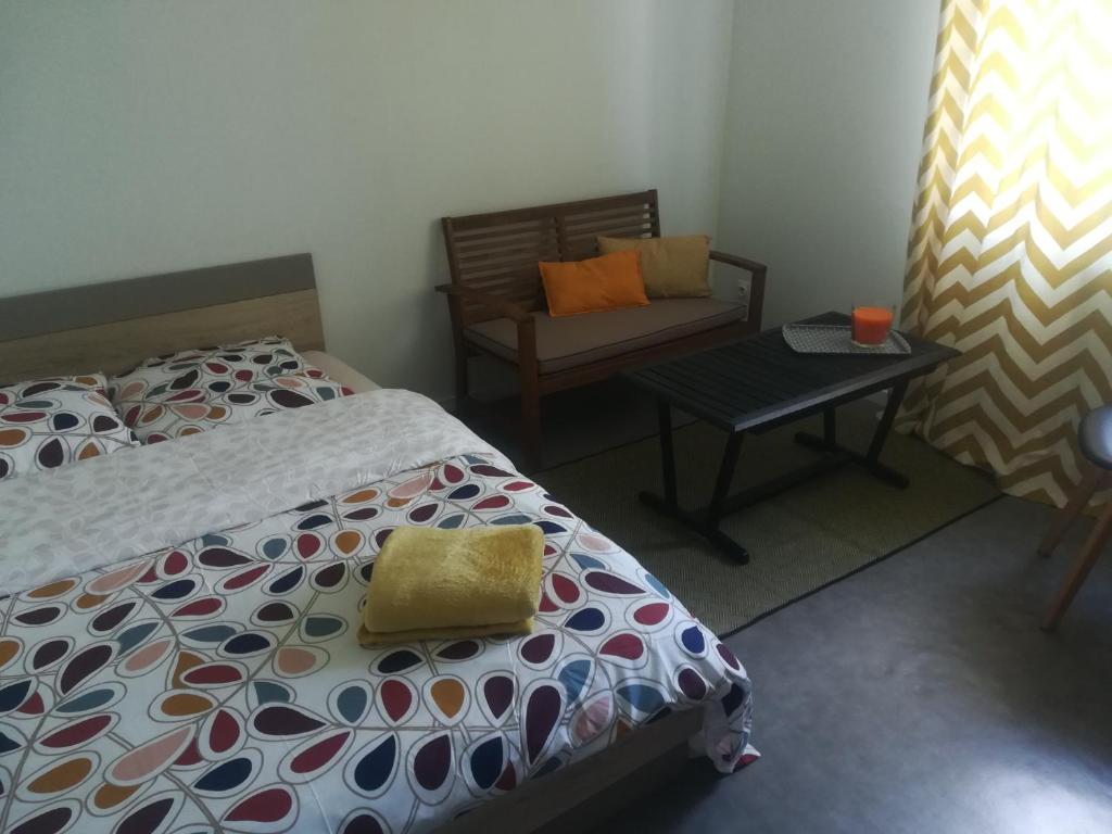 une chambre avec un lit, une chaise et une table dans l'établissement Appart agréable 2 chambres Quartier calme toutes commodités, à La Rochelle