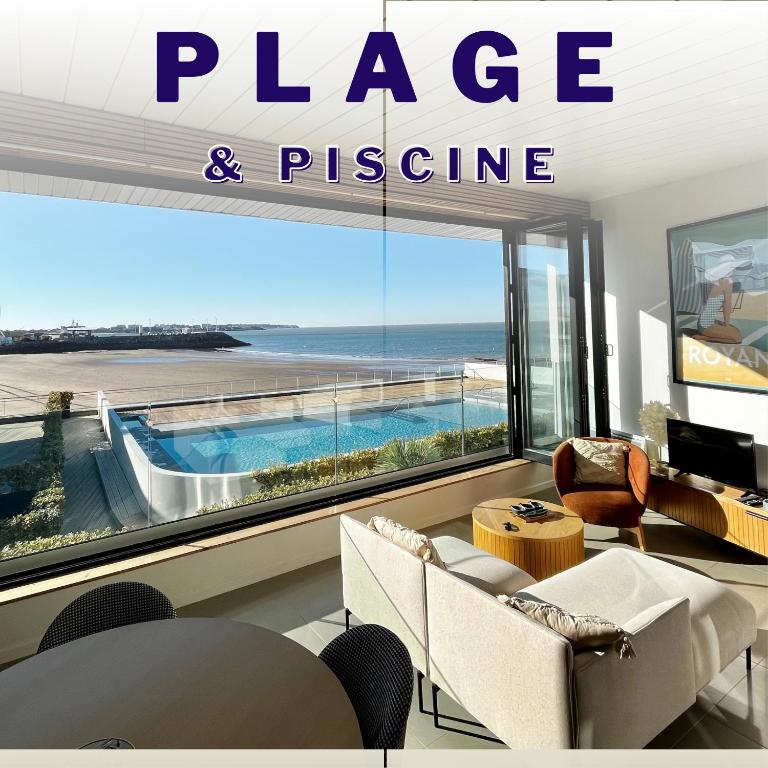 un salon avec une grande fenêtre avec vue sur l'océan dans l'établissement Le Sunrise - panorama sur l'estuaire, à Royan