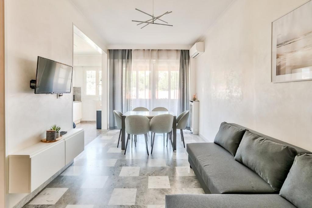 un salon avec un canapé, une table et des chaises dans l'établissement Superbe T2 avec terrasse et parking, à Nice