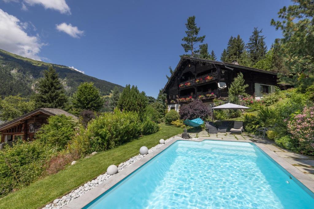 een huis met een zwembad in de tuin bij Chalet authentique luxe piscine in Les Contamines-Montjoie