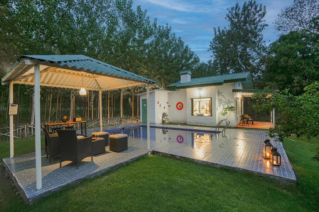 a backyard with a swimming pool and a pavilion at SaffronStays Dalewal Jungle Lodge, Hoshiarpur in Hoshiārpur