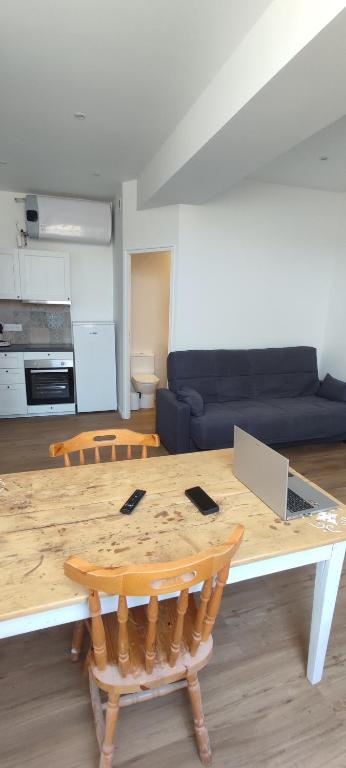 un salon avec une table et un canapé dans l'établissement Appartement 1G 35m2 1 etage, à Saujon