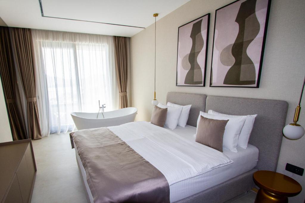 a hotel room with a bed and a bath tub at Regent Resort Budva in Budva
