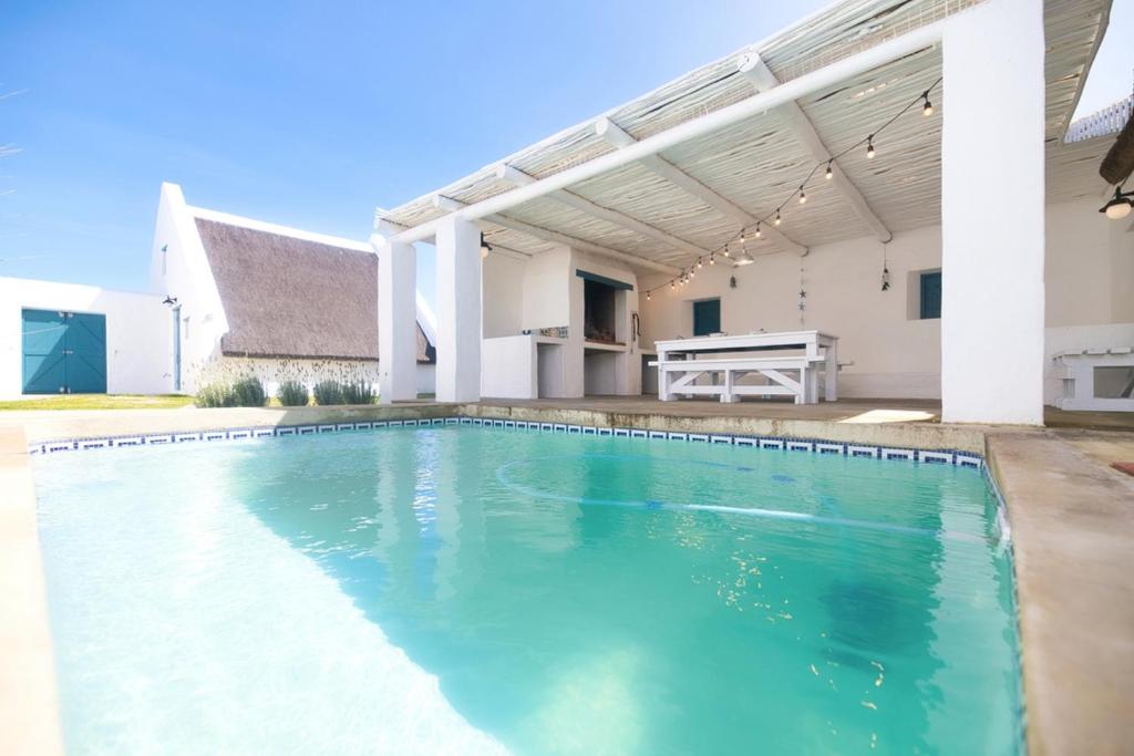 una piscina davanti a una casa di Skulpies Cottage Langezandt In Struisbaai a Struisbaai