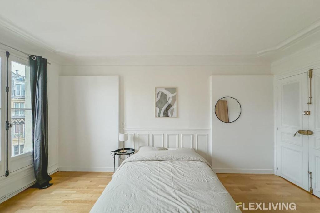 une chambre blanche avec un lit et une fenêtre dans l'établissement Flexliving - room - Turbigo, à Paris