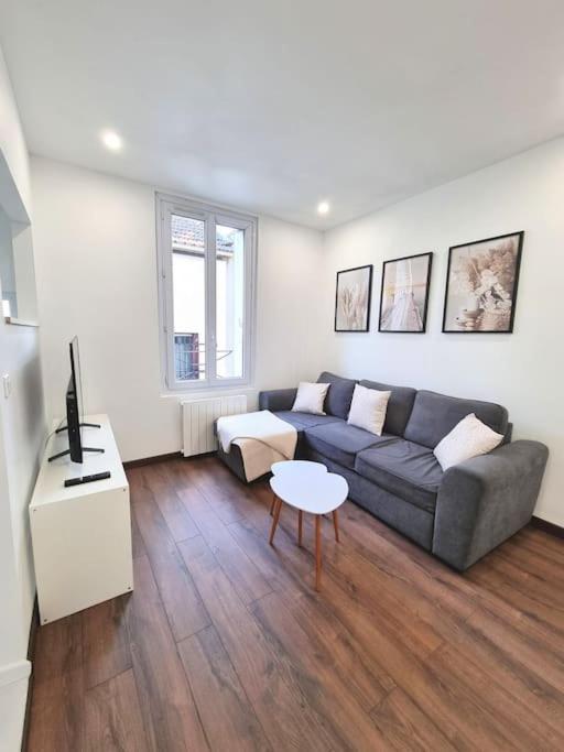 un salon avec un canapé et une table dans l'établissement Le Fort - Maison individuelle proche Stade de France, à Aubervilliers